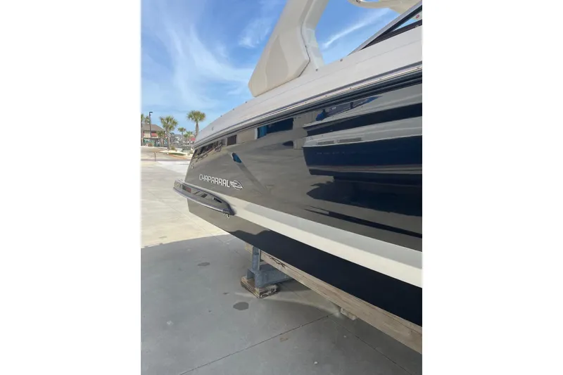 Slide: The Image of 2019 Chaparral 297 SSX boat side view with sleek design and logo. - 25