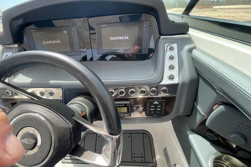 Slide: The Image of 2019 Chaparral 297 SSX boat dashboard with Garmin navigation displays and steering wheel. - 33