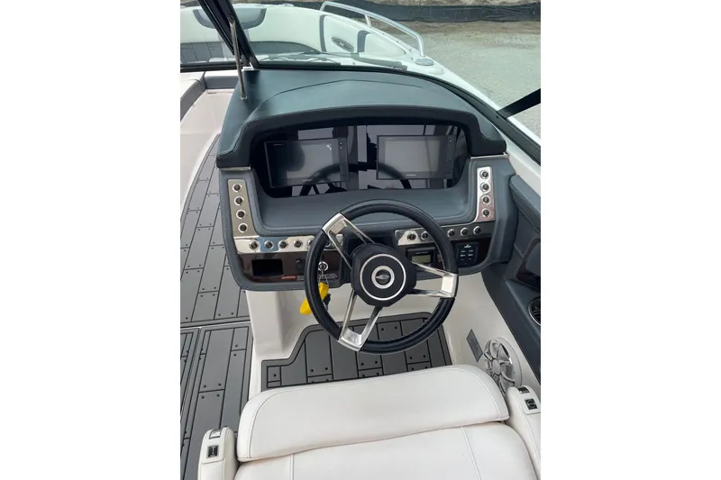 Slide: The Image of 2019 Chaparral 297 SSX boat dashboard with steering wheel and control panel. - 39