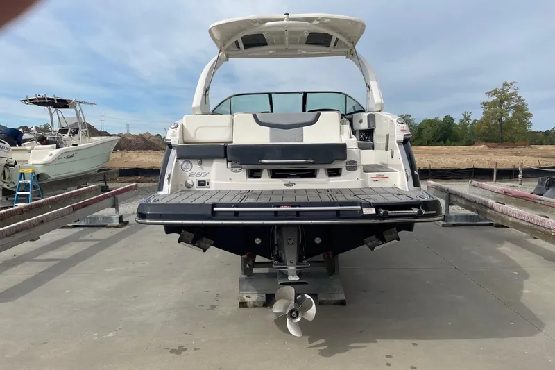 Slide: The Image of 2019 Chaparral 297 SSX boat on a dock, rear view showing propeller and deck. - 49