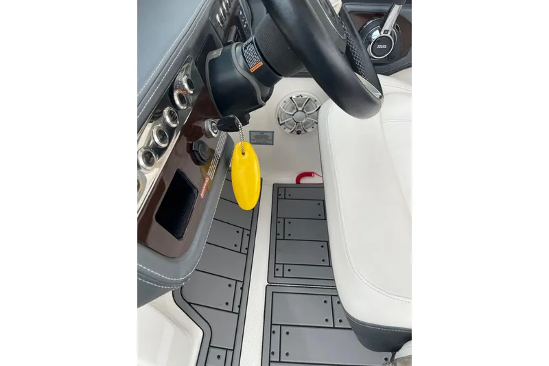 Slide: The Image of 2019 Chaparral 297 SSX boat interior, featuring steering wheel, controls, and white seating. - 6