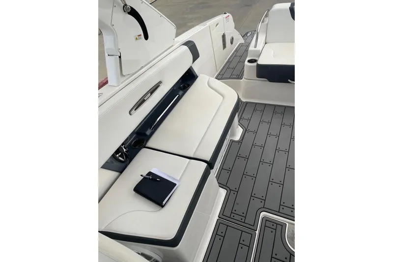 Slide: The Image of 2019 Chaparral 297 SSX boat interior with white seating and gray flooring. - 8