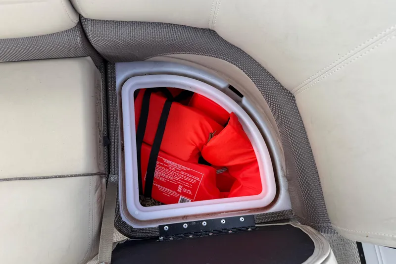Slide: The Image of Storage compartment with life jackets in a 2023 Regency 230 DL3 boat. - 22