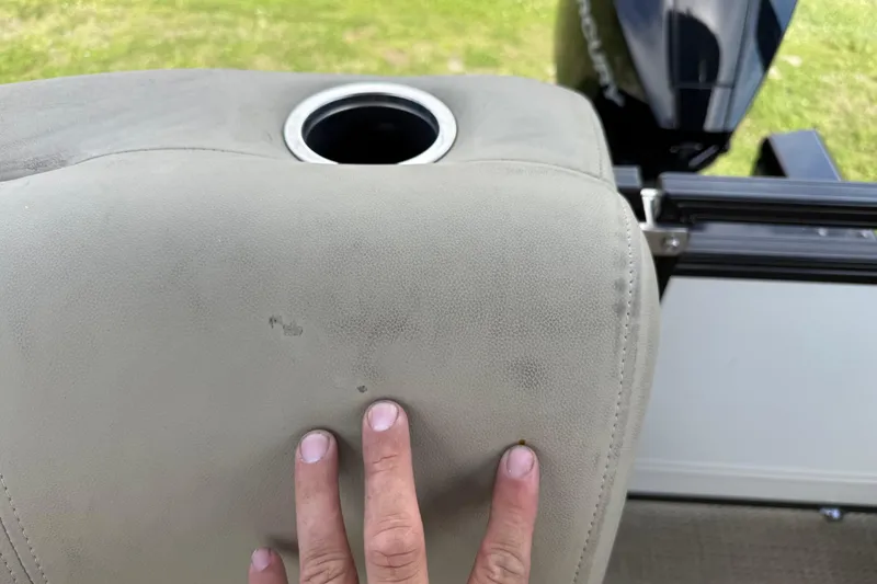 Slide: The Image of Hand touching beige seat with cup holder on 2023 Regency 230 DL3 boat. - 23