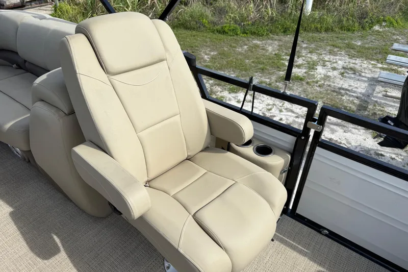Slide: The Image of Luxurious beige seating on 2023 Regency 230 DL3 pontoon boat, featuring cup holders and armrests. - 28