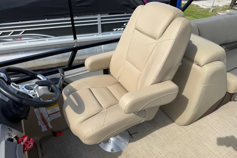 Slide: The Image of Beige captain's chair and steering wheel on 2023 Regency 230 DL3 boat. - 29