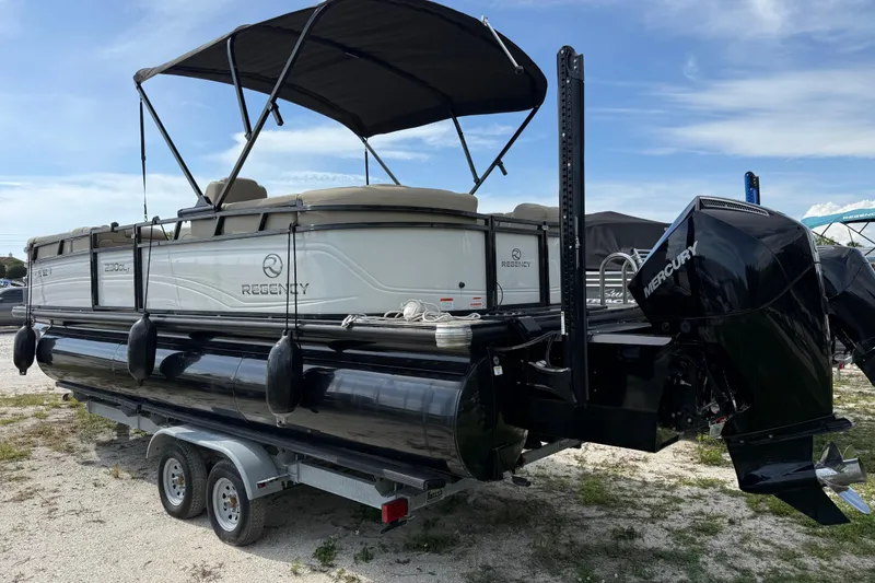 Slide: The Image of 2023 Regency 230 DL3 pontoon boat with Mercury engine on a trailer. - 3