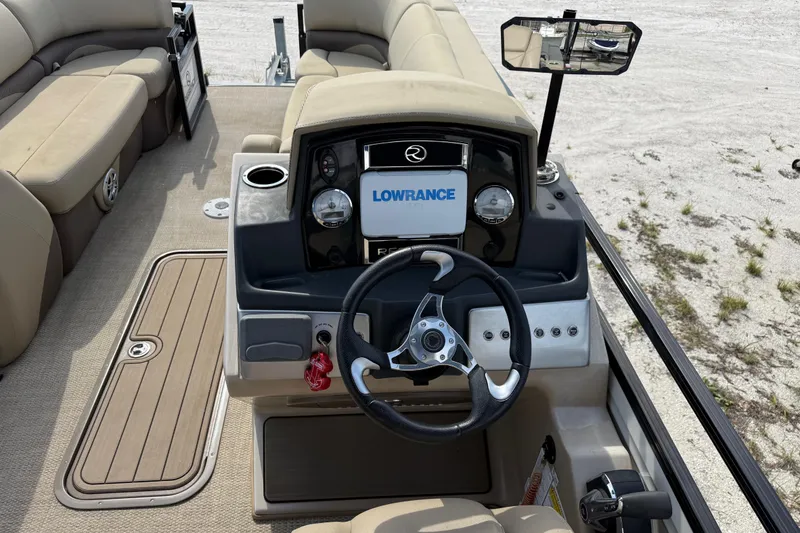 Slide: The Image of 2023 Regency 230 DL3 boat dashboard with steering wheel and Lowrance display. - 32