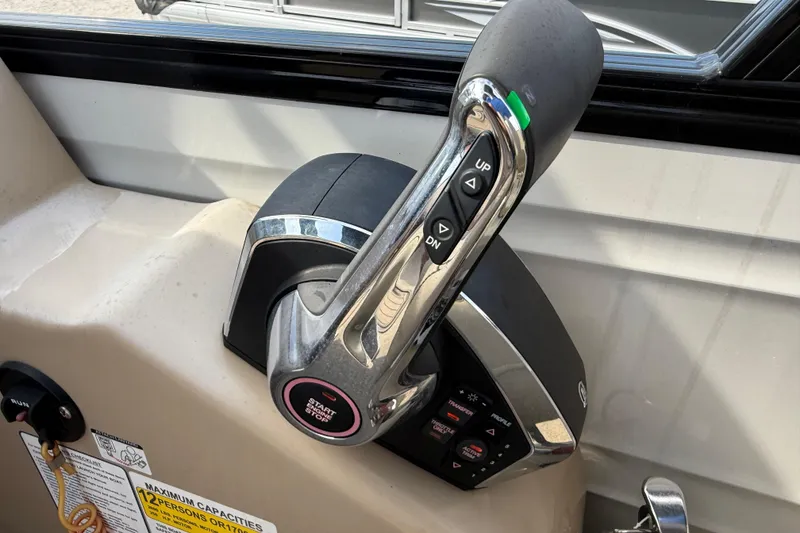 Slide: The Image of Throttle control of 2023 Regency 230 DL3 boat with start/stop button and trim controls. - 38