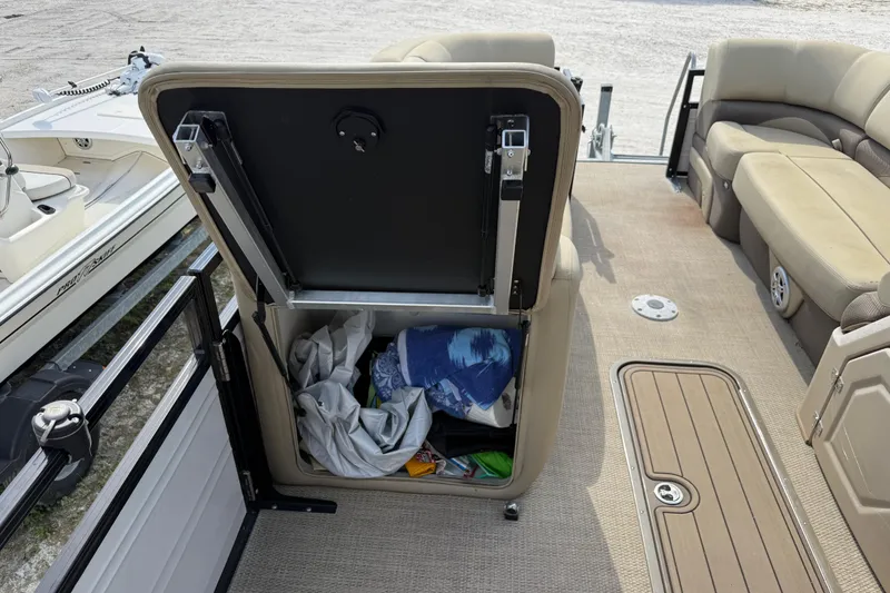 Slide: The Image of 2023 Regency 230 DL3 boat interior with open storage compartment and seating area. - 48