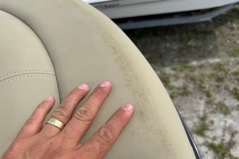 Slide: The Image of Hand touching beige upholstery on 2023 Regency 230 DL3 boat seat. - 50