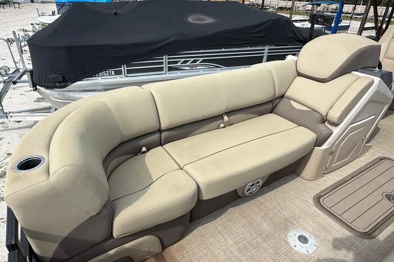 Slide: The Image of Luxurious seating on 2023 Regency 230 DL3 pontoon boat, featuring beige upholstery and cup holder. - 51