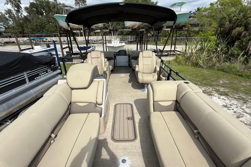 Slide: The Image of 2023 Regency 230 DL3 pontoon boat with beige seating and spacious deck. - 55