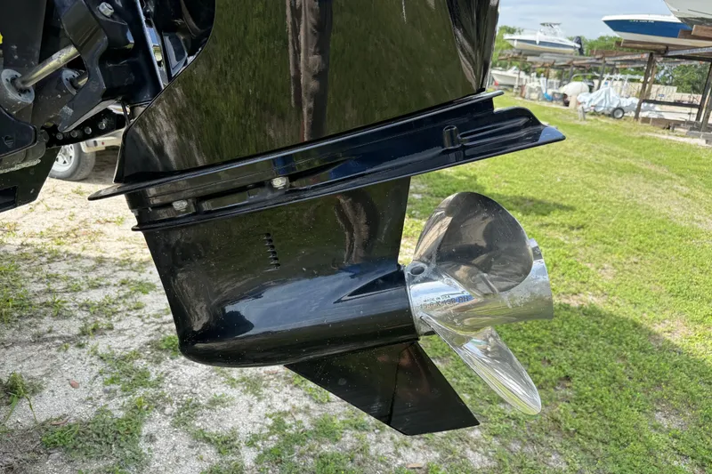 Slide: The Image of Close-up of a 2023 Regency 230 DL3 boat propeller on grassy ground. - 8