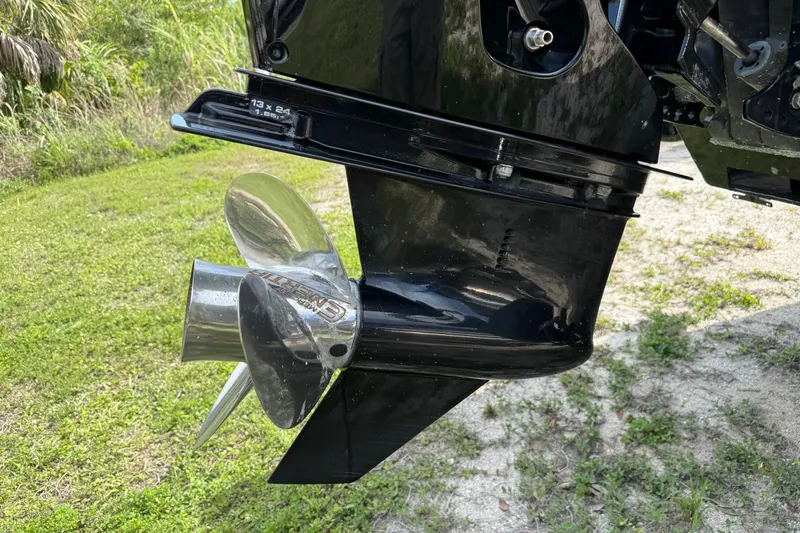 Slide: The Image of Close-up of a 2023 Regency 230 DL3 boat propeller on grassy terrain. - 9