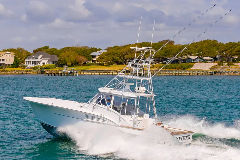 Slide: The Image of Custom Lohr 43 Express 1999 yacht cruising on water, coastal homes in background. - 3