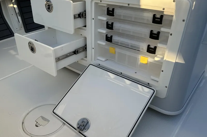 Slide: The Image of Storage compartments on a 2026 Pathfinder 2600 TRS boat, featuring drawers and tackle boxes. - 16