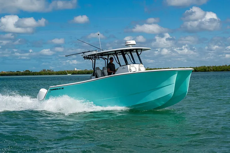 Slide: The Image of 2025 Hammer Yachts 30 cruising on clear waters under a blue sky. - 12