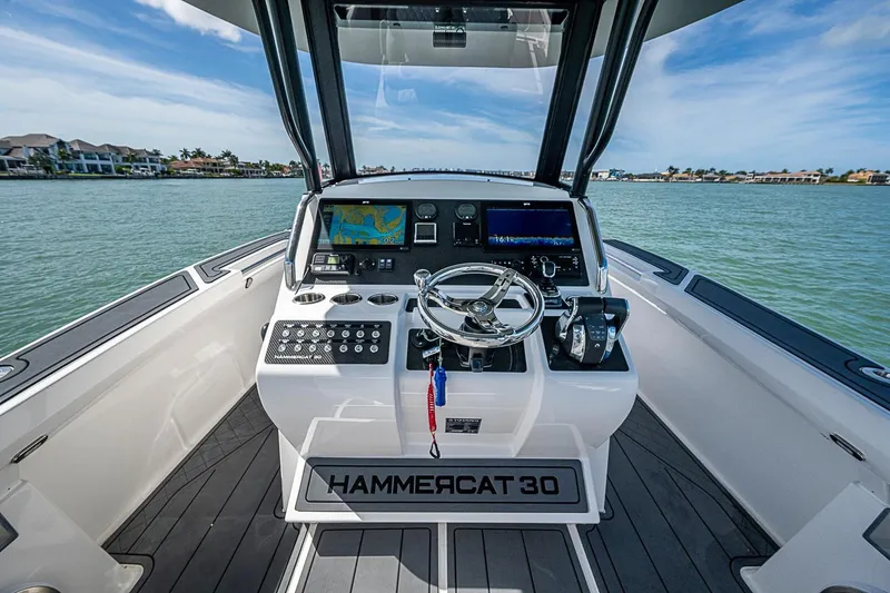 Slide: The Image of Cockpit view of 2025 Hammer Yachts Hammercat 30 on calm waters. - 16