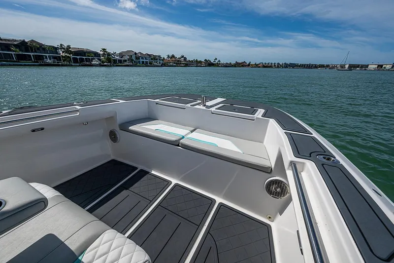 Slide: The Image of 2025 Hammer Yachts 30 boat interior with cushioned seating, on calm waters under a blue sky. - 29