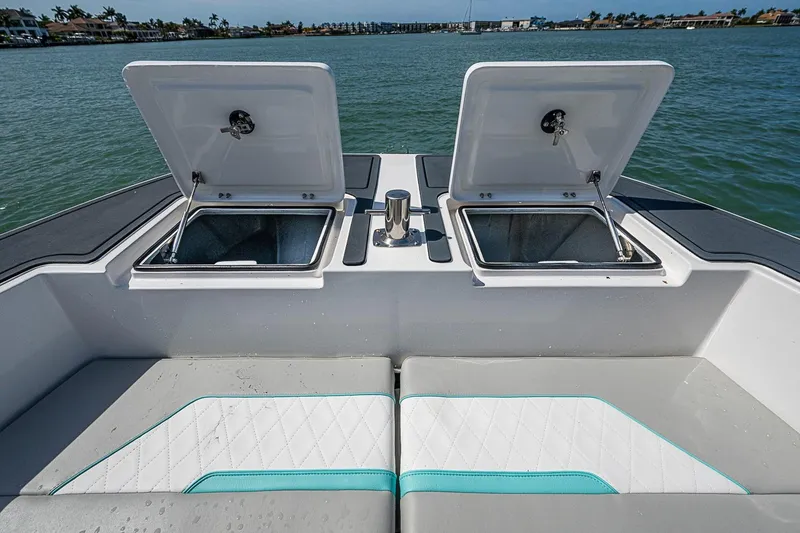 Slide: The Image of 2025 Hammer Yachts 30 boat with open storage compartments and cushioned seating on deck. - 30