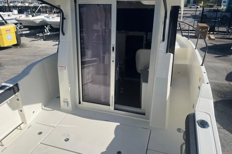 Slide: The Image of 2025 Bayliner Trophy T25 Pilothouse boat deck with sliding door and seating area. - 14