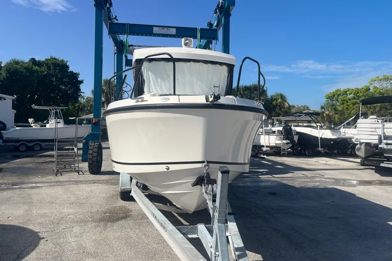 Slide: The Image of 2025 Bayliner Trophy T25 Pilothouse boat on trailer in marina setting. - 3