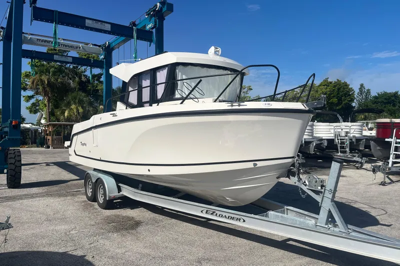 Slide: The Image of 2025 Bayliner Trophy T25 Pilothouse boat on trailer under clear blue sky. - 4