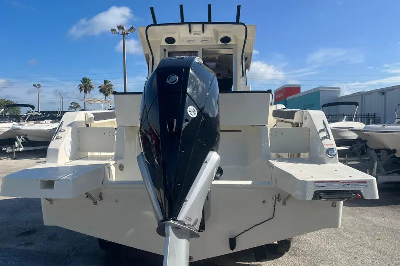 Slide: The Image of 2025 Bayliner Trophy T25 Pilothouse boat with powerful outboard motor, docked outdoors. - 6