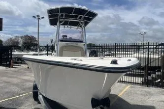Slide: The Image of 2023 NauticStar 2302 Legacy boat in a marina under a cloudy sky. - 3