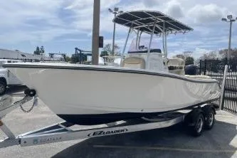 Slide: The Image of 2023 NauticStar 2302 Legacy boat on trailer, parked outdoors under cloudy sky. - 4