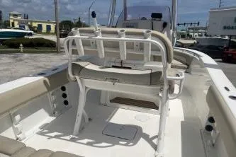 Slide: The Image of 2023 NauticStar 2302 Legacy boat interior with seating and console, parked outdoors. - 7