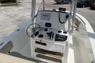 Slide: The Image of 2023 NauticStar 2302 Legacy boat cockpit with steering wheel and control panel. - 8