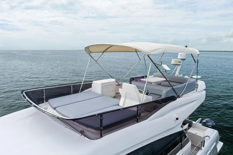 Slide: The Image of 2018 Ferretti Yachts 550 flybridge with canopy, overlooking serene ocean waters. - 25