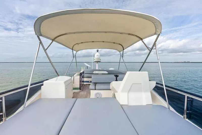 Slide: The Image of 2018 Ferretti Yachts 550 flybridge with canopy, overlooking serene ocean waters. - 30