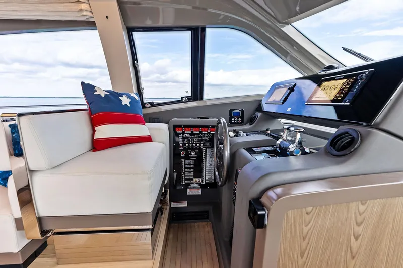 Slide: The Image of 2018 Ferretti Yachts 550 helm with modern controls and star-themed cushion. - 58