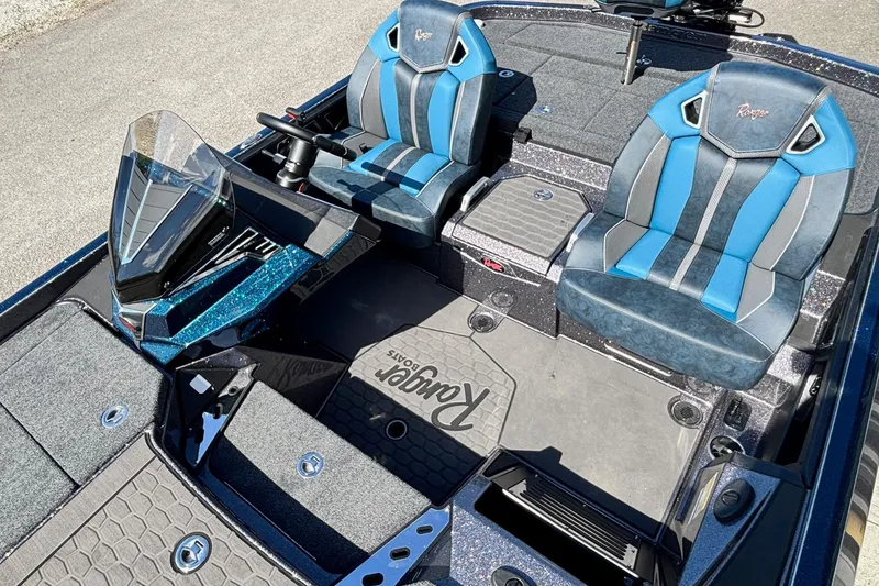 Slide: The Image of 2025 Ranger Z520R boat interior with blue and gray seats, steering console, and storage compartments. - 6