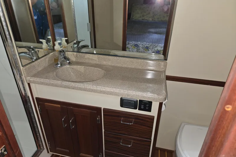 Slide: The Image of Bathroom vanity in 2009 American Tug 34 Rare Flybridge Model, featuring sink and storage cabinets. - 10