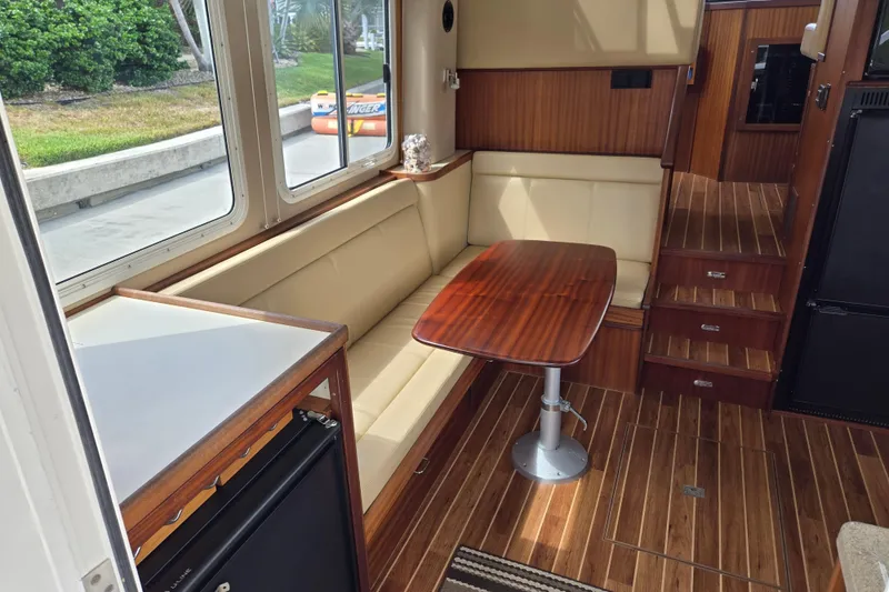 Slide: The Image of Interior of 2009 American Tug 34, featuring a cozy dining area with wood accents. - 15