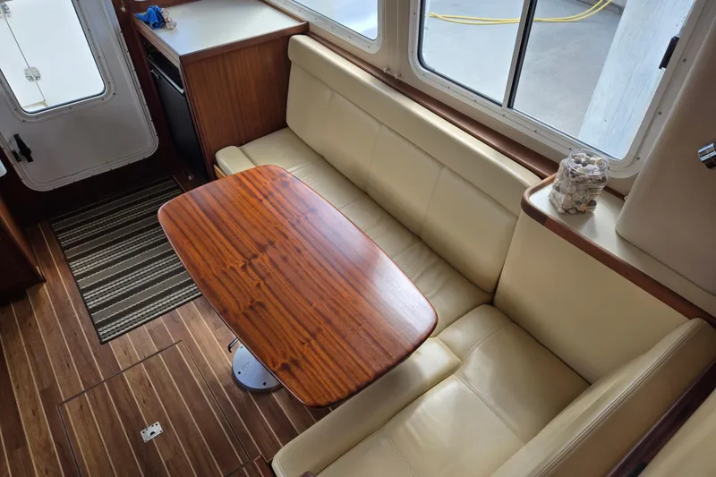 Slide: The Image of Interior of 2009 American Tug 34 Rare Flybridge Model with wooden table and beige seating. - 17