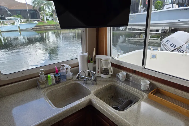Slide: The Image of 2009 American Tug 34 Rare Flybridge Model kitchen with sink, coffee maker, and marina view. - 22