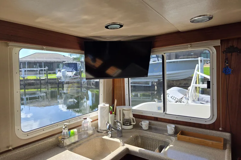 Slide: The Image of Interior of 2009 American Tug 34 Rare Flybridge Model with kitchen sink and window view. - 23