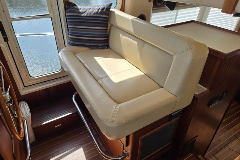 Slide: The Image of Interior of 2009 American Tug 34 Rare Flybridge Model with beige seating and striped pillow. - 30
