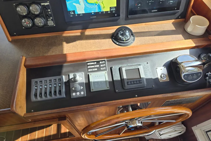 Slide: The Image of American Tug 34 Rare Flybridge Model 2009 helm with navigation controls and wooden steering wheel. - 32