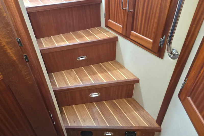 Slide: The Image of Wooden stairs inside 2009 American Tug 34 Rare Flybridge Model, featuring elegant cabinetry. - 48