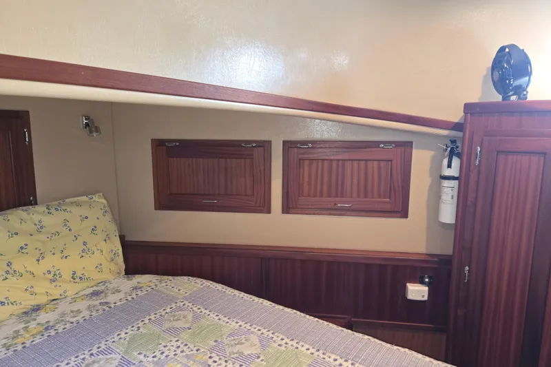 Slide: The Image of Cozy cabin interior of 2009 American Tug 34 Rare Flybridge Model with wood paneling and floral bedding. - 50