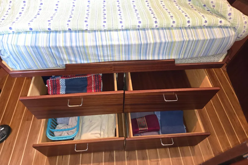 Slide: The Image of Under-bed storage drawers in 2009 American Tug 34 Rare Flybridge Model, featuring organized linens. - 54