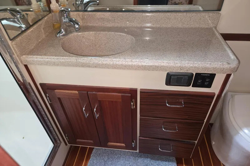 Slide: The Image of 2009 American Tug 34 bathroom with granite countertop, wooden cabinets, and modern fixtures. - 63