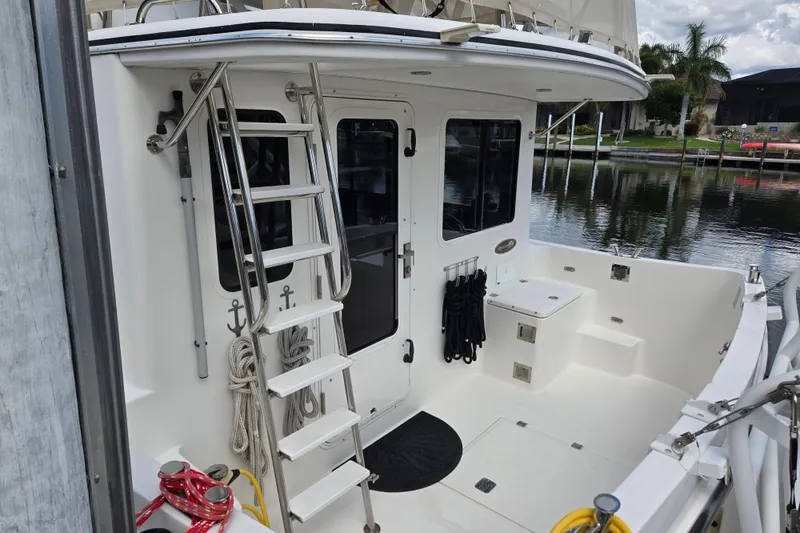Slide: The Image of 2009 American Tug 34 Rare Flybridge Model, featuring a spacious deck and ladder access. - 80