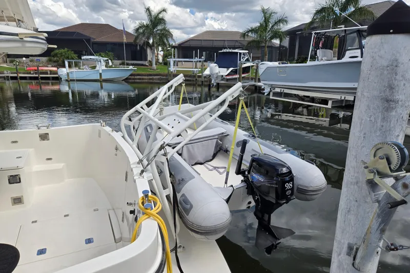 Slide: The Image of 2009 American Tug 34 Rare Flybridge Model with dinghy and outboard motor in marina. - 81